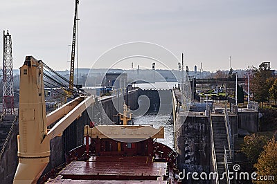 Merchant ship vessel with two cranes passing locks in the Great Lakes, Canada in winter time. Editorial Stock Photo