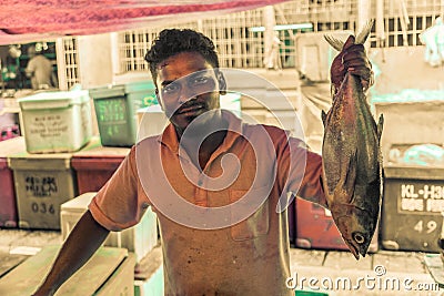 Merchant showing fish Editorial Stock Photo