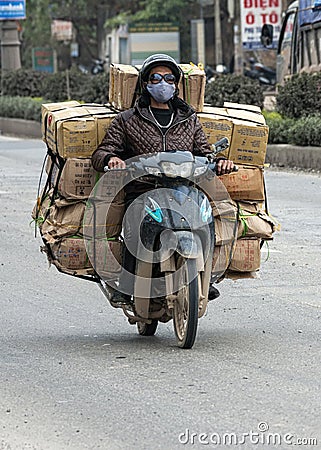 Merchant transports many boxes on the back of motorcycle. Editorial Stock Photo