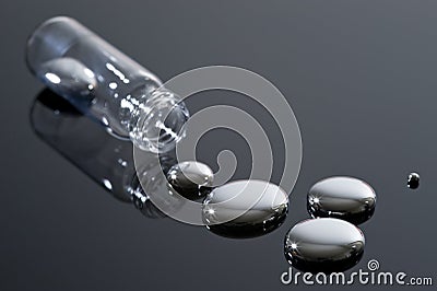 Mercury and glass container on a reflective surfac Stock Photo