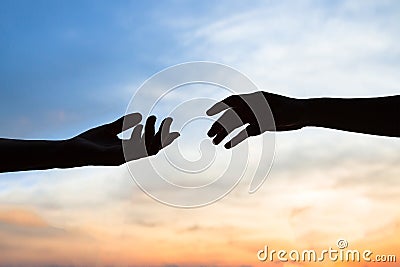 Mercy, two hands silhouette on sky background, connection or help concept Stock Photo