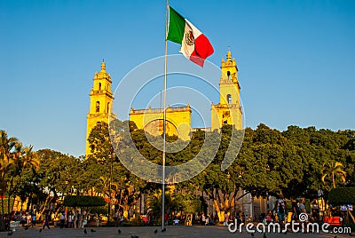 Merida San Ildefonso cathedral in the evening. Mexican flag flutters on air. Yucatan. Mexico Editorial Stock Photo