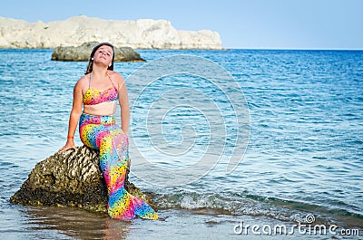 Mermaid girl posing on the beach rock Stock Photo