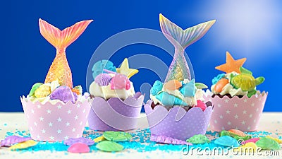 Mermaid theme cupcakes with colorful glitter tails, shells and sea creatures. Stock Photo