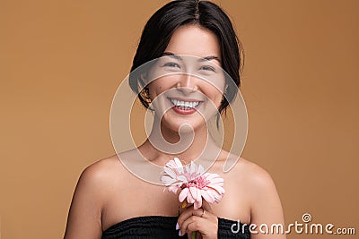 Merry Asian female model with gerbera Stock Photo