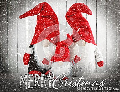 Merry Christmas! Cute gnomes on table against white wooden background Stock Photo