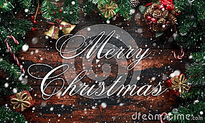 Merry Christmas displayed on a rustic wooden table with decoration, gifts, snow, tree branch Stock Photo