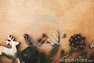 Merry Christmas flat lay. Stylish rustic reindeer, pine branches, cones, gingerbread cookies,thread, cinnamon, anise on rural Stock Photo