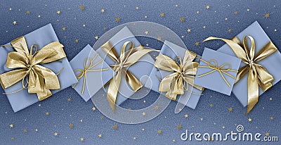 Merry christmas, gift box with golden ribbon bow isolated on blue sparkle background with stars, gift greeting card ticket top Stock Photo