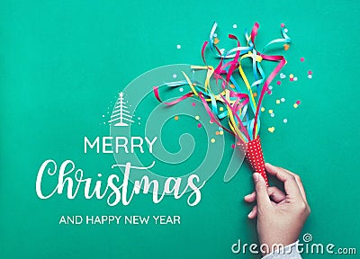 Merry christmas with hand holding colorful confetti,streamers Stock Photo