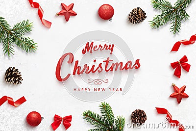 Merry Christmas and Happ New Year greeting card with Christmas derorations. Red text surrounded by tree branches Stock Photo