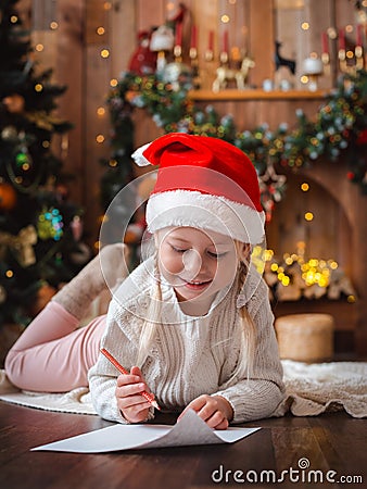 Little child girl writes letter Santa Claus and dreams of a gift background Stock Photo
