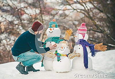 Merry Christmas and Happy new year. Enjoying nature wintertime. Snowman and funny bearded man in the snow. Happy smiling Stock Photo