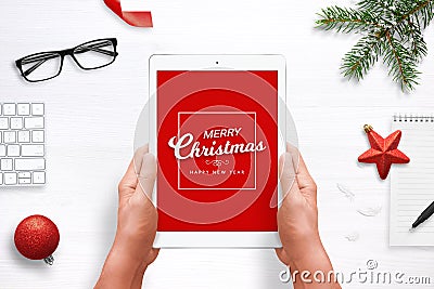 Merry Christmas and Happy New Year greeting card on tablet with red background. Top view composition with Christmas, New Year deco Stock Photo