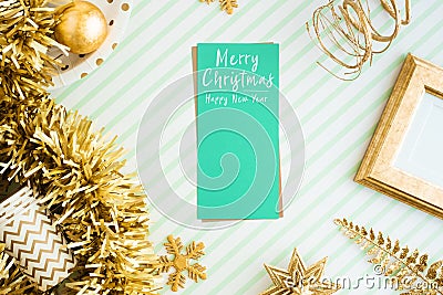 Merry christmas and happy new year greeting card view of sparkling gold tinsel,ball,ornament decorate on green strip line table. Stock Photo