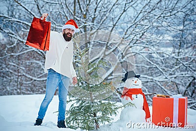 Merry Christmas and Happy new year. Christmas shop or store. Winter emotion. Snowman and funny bearded man with gift - Stock Photo