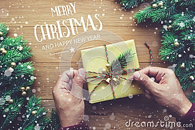 MERRY CHRISTMAS AND HAPPY NEW YEAR typography,text with human hand decorating gift box presents Stock Photo