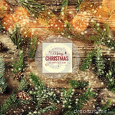 Merry Christmas and New Year card on wooden background with fir branches, pine cones and snowflakes on wooden background Stock Photo