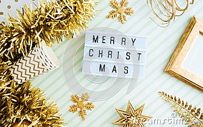 Merry christmas onl lightbox background.top view of sparkling gold tinsel,ball,ornament decorate on green strip line table.holiday Stock Photo