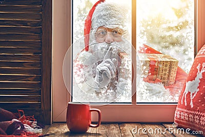 Santa Claus is knocking at window Stock Photo
