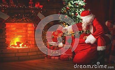 Merry Christmas! santa claus near the fireplace and tree with gi Stock Photo