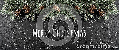 Merry Christmas Typographical on dark holiday background with frame of Fir branches, pine cones Stock Photo