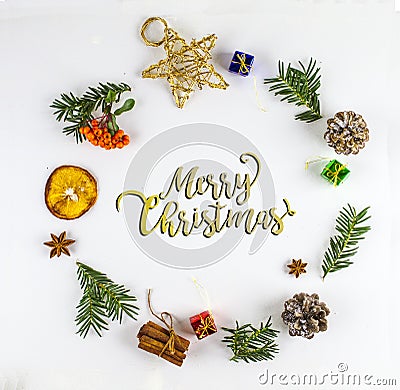 MERRY CHRISTMAS TYPOGRAPHY. FIR BRANCH AND CHRISTMAS DECOR ORNAMENT IN CIRCLE Stock Photo