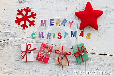 `Merry Chritsmas` letters, Christmas decoration and gift boxes on white wooden Stock Photo