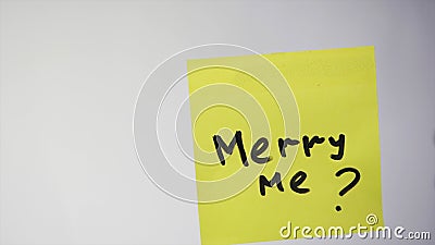 Merry me is an inscription on a piece of paper. Inscription on the sticker merry me on a white background Stock Photo
