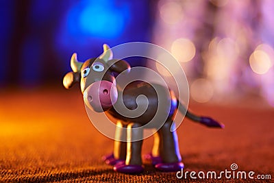 Merry plasticine cow from Christmas series and blurred lights Stock Photo