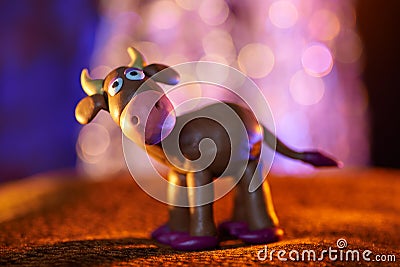 Merry plasticine cow from Christmas series and blurred lights Stock Photo