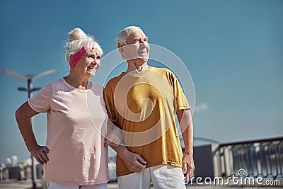 Two smiling pleased aged people standing outside Stock Photo