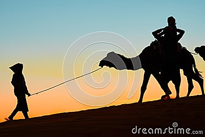 Merzouga, Morocco - December 03, 2018: backlight camels sunset Editorial Stock Photo