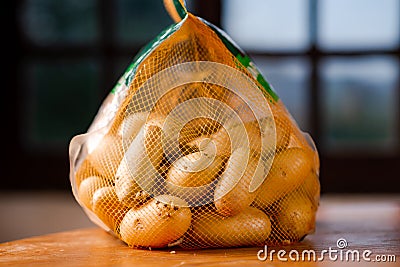 Mesh bag with whole potatoes. Sale or purchase of potatoes Stock Photo