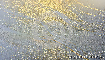 Mesmerizing close-up of a golden splatter gracefully adorning a transparent glass surface Stock Photo