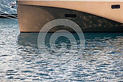 The mesmerizing reflection of the water on the glossy side of a huge yacht anchored, chrome details Stock Photo