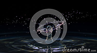 Mesmerizing water drop collision creating splash in dark background Stock Photo
