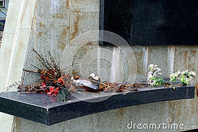 Dried abandoned flowers on a monument shelf Stock Photo