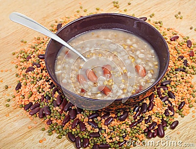Mess of pottage in bowl with tablespoon on plate Stock Photo