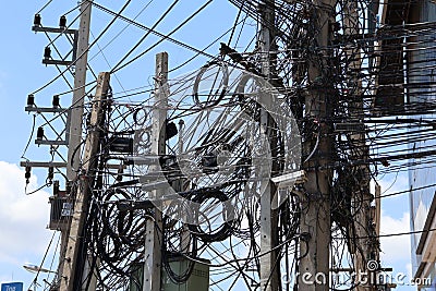 A mess of power poles and wires, cabling systems, and internet towers are dangerous. Stock Photo