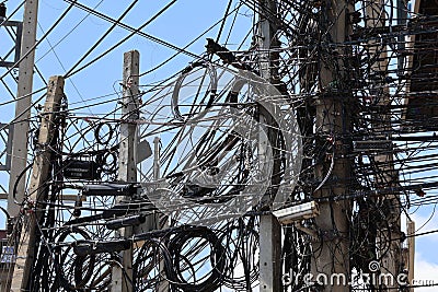 A mess of power poles and wires, cabling systems, and internet towers are dangerous. Stock Photo