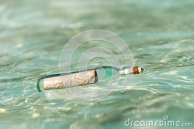 Message in a bottle washed ashore on tropical beach. Stock Photo