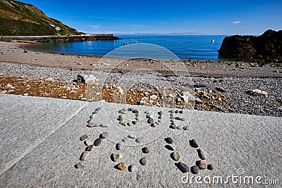 Message in pebbles on beach Stock Photo