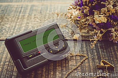 The message on the screen: Happy Valentine`s Day with fower on wooden background . Old ancient pager style vintage Stock Photo