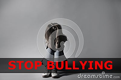 Message STOP BULLYING and sad woman sitting Stock Photo