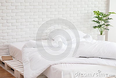 Messed bed with white pillow and blanket with natural light Stock Photo
