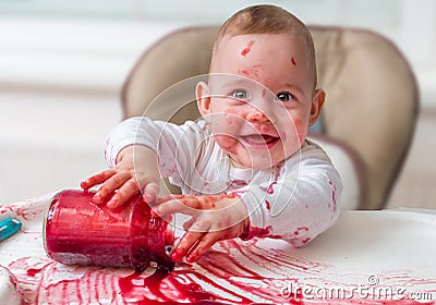 Messy and dirty baby is eating snack with hands Stock Photo