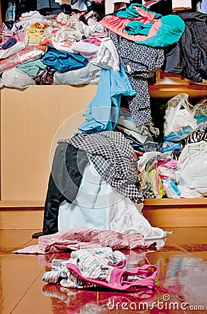 Messy disorder clothes over the closet. Untidy cluttered woman c Stock Photo