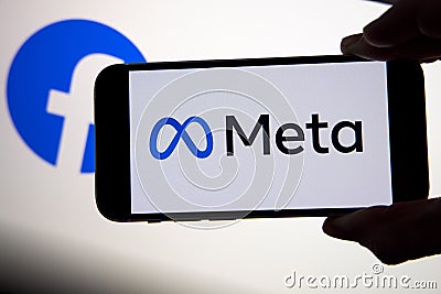 META company logo seen on smartphone with Facebook logo on background screen. Editorial Stock Photo