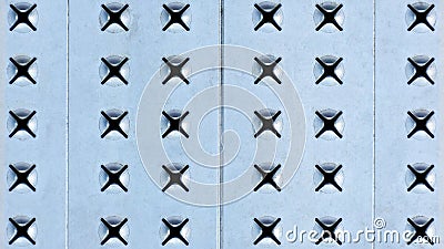 Metal background of light perforated steel. X-shaped holes in the iron sheet. Stock Photo